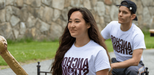 Two students wearing teeshirts that say "anchor strong" smiling on the quad